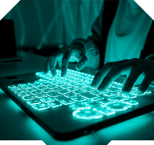 Pessoa programando em um teclado com iluminação ciano.